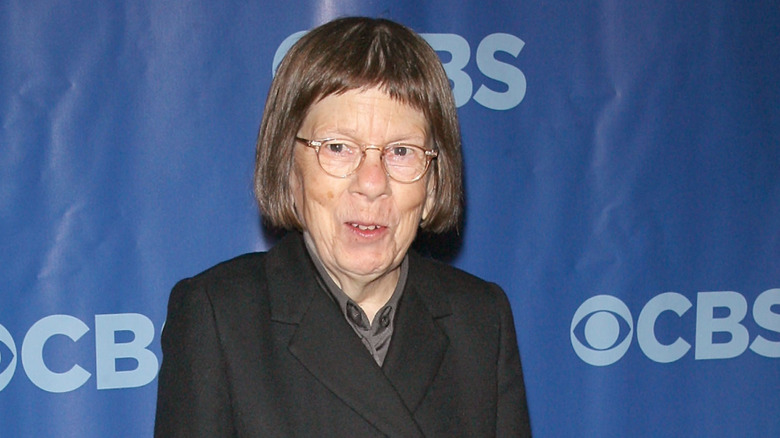 Linda Hunt poses against a blue backdrop with a gentle smile.