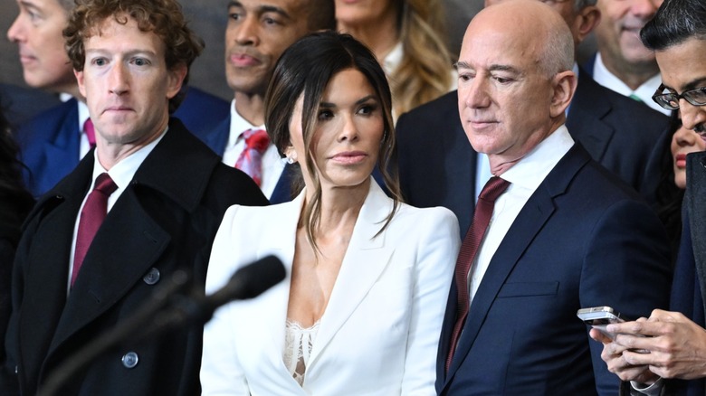 Dressed in a white suit and a lacy top, Lauren Sánchez looks away from the camera.