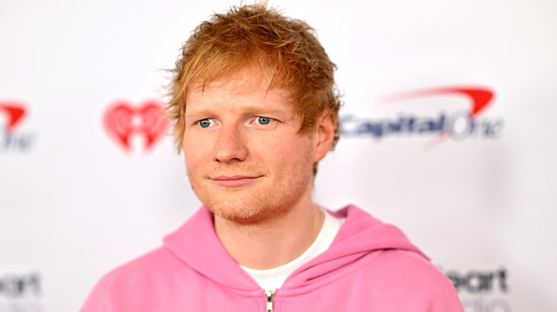 Ed Sheeran wearing a pink hoodie.