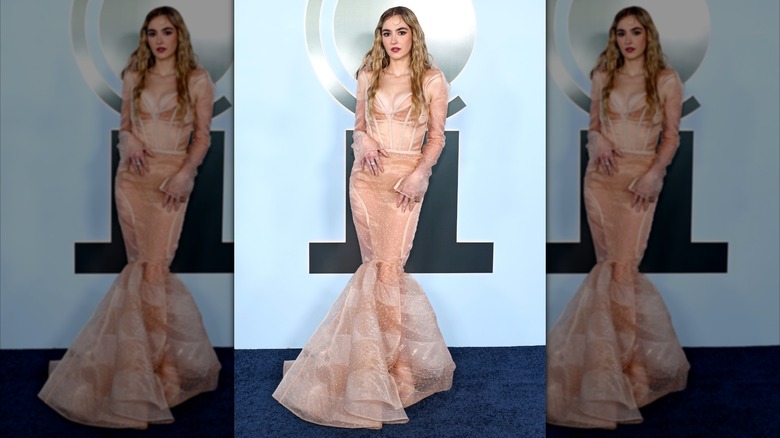 Hannah Cruz posing at the 2026 Tony Awards in a tan dress.