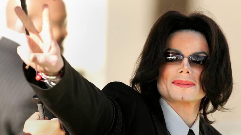 Michael Jackson flashing the peace sign while wearing sunglasses