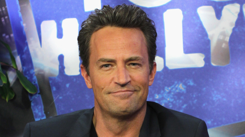 Matthew Perry wearing a black blazer and black t-shirt