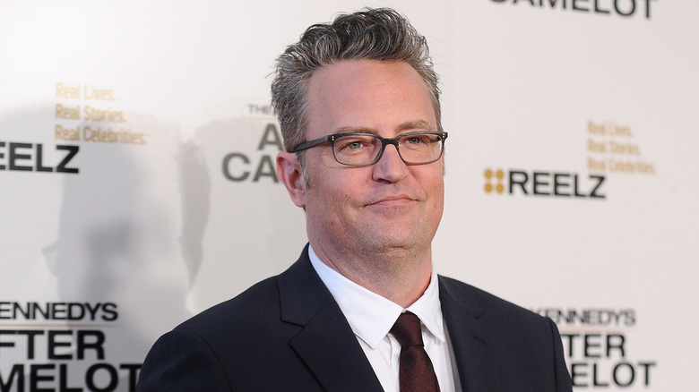 Matthew Perry wearing a suit and tie at a red carpet event
