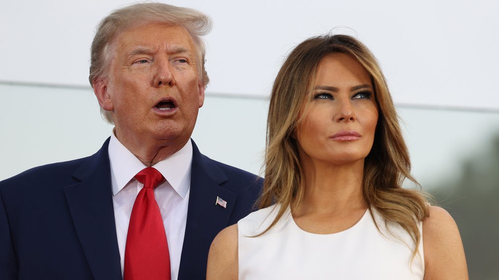 Donald Trump standing behind Melania Trump