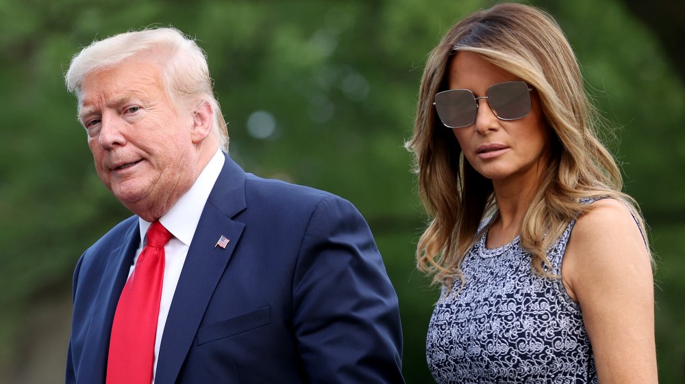 Donald Trump and Melania Trump walking, both with serious expressions