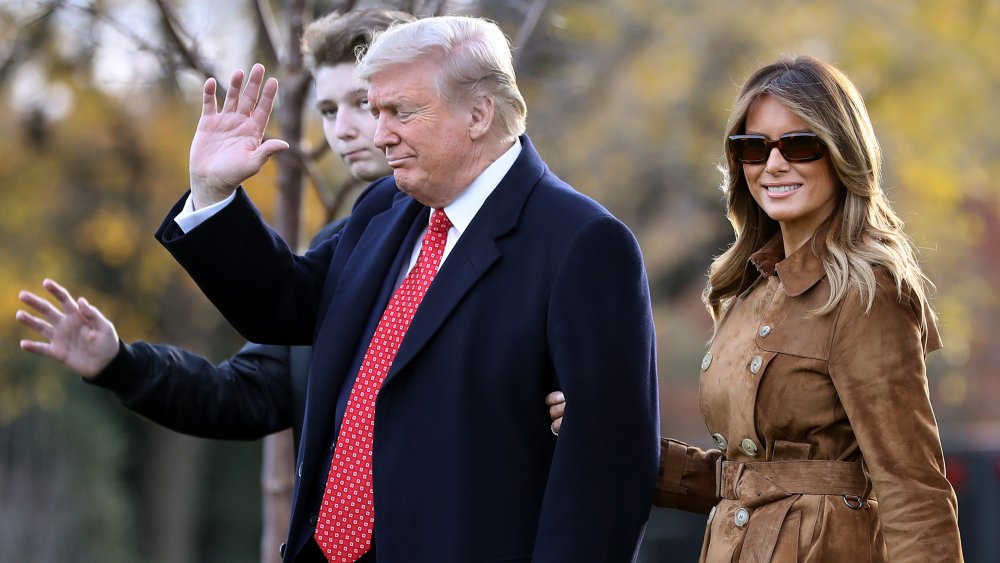 Barron, Donald, and Melania Trump walking outside