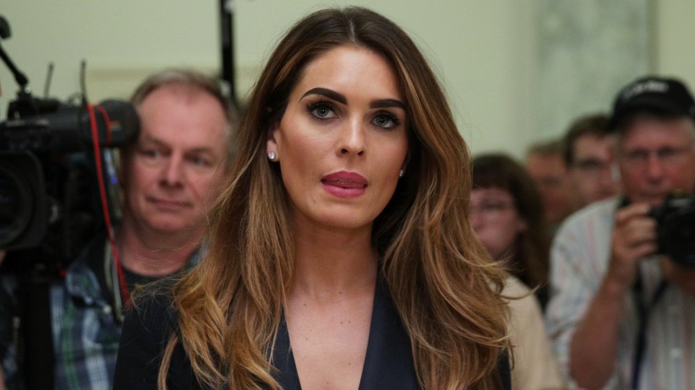 Hope Hicks speaking, surrounded by press and photographers