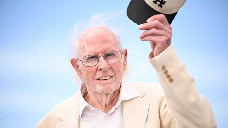 Bruce Dern posing in a white suit while holding a hat at the 2026 Cannes Film Festival