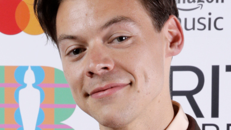Harry Styles, smiling with no teeth showing, no facial hair, hair short, Brit Awards 2021 red carpet 