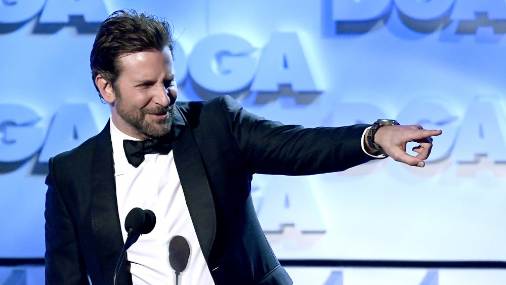 Bradley Cooper pointing off stage during an award show appearance 