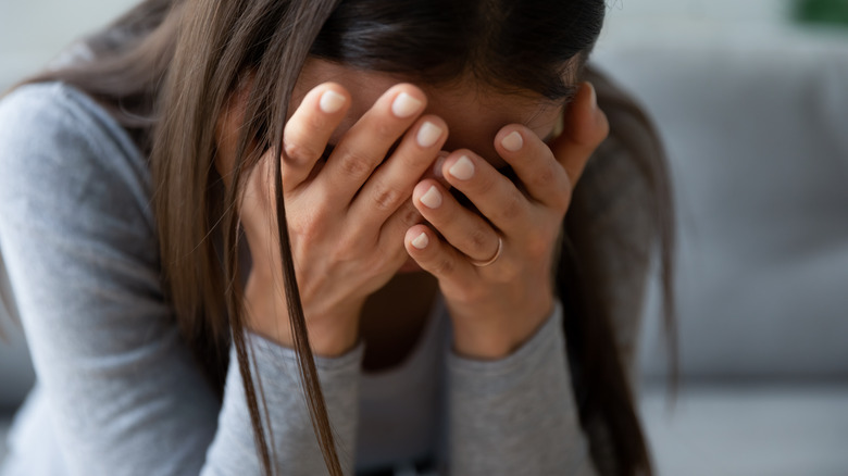 Woman crying with head in hands