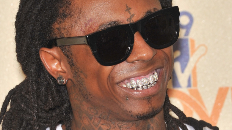 Lil Wayne smiling at an event with sunglasses on