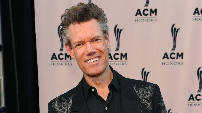 Randy Travis poses in a dark outfit in 2010.
