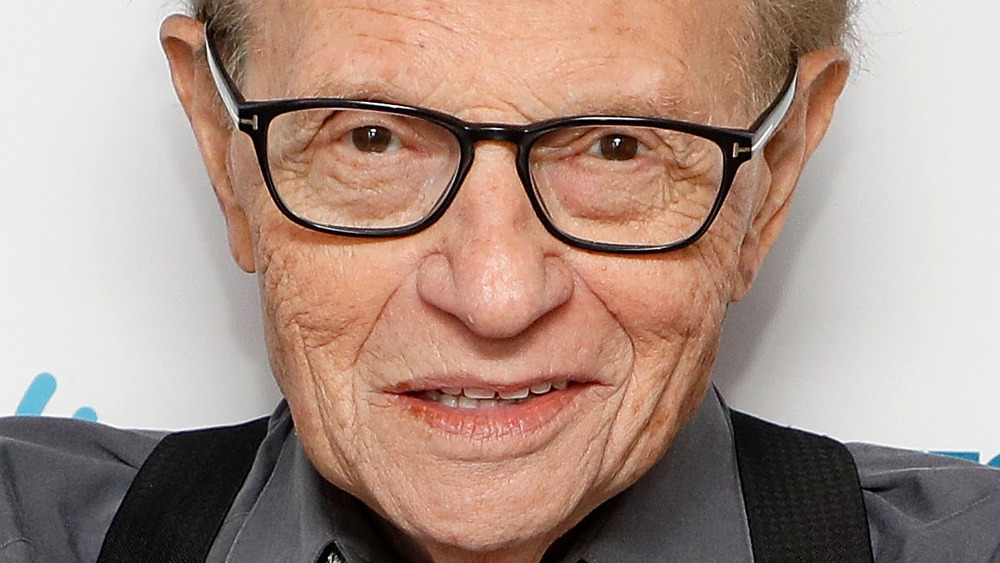 Larry King poses with his arms crossed.