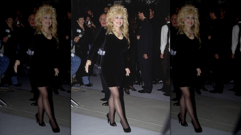 Dolly Parton, wearing a black outfit, takes a step.