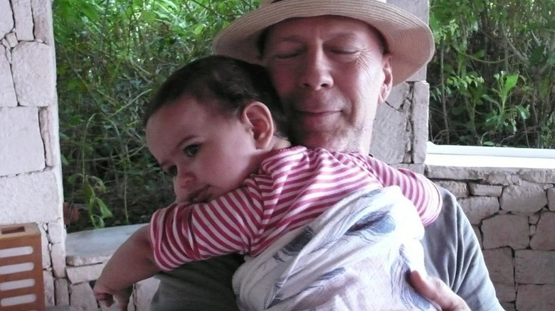 Bruce Willis holding a baby