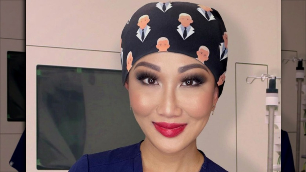 Tiffany Moon wearing red lipstick and blue scrubs