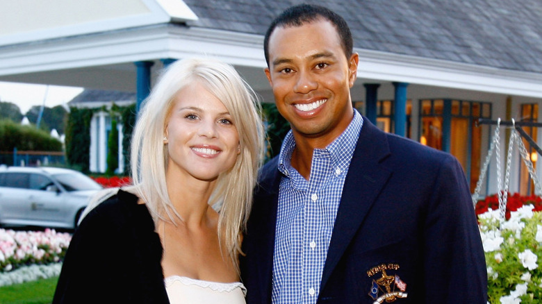 Tiger Woods and Elin Nordegren smiling outside building