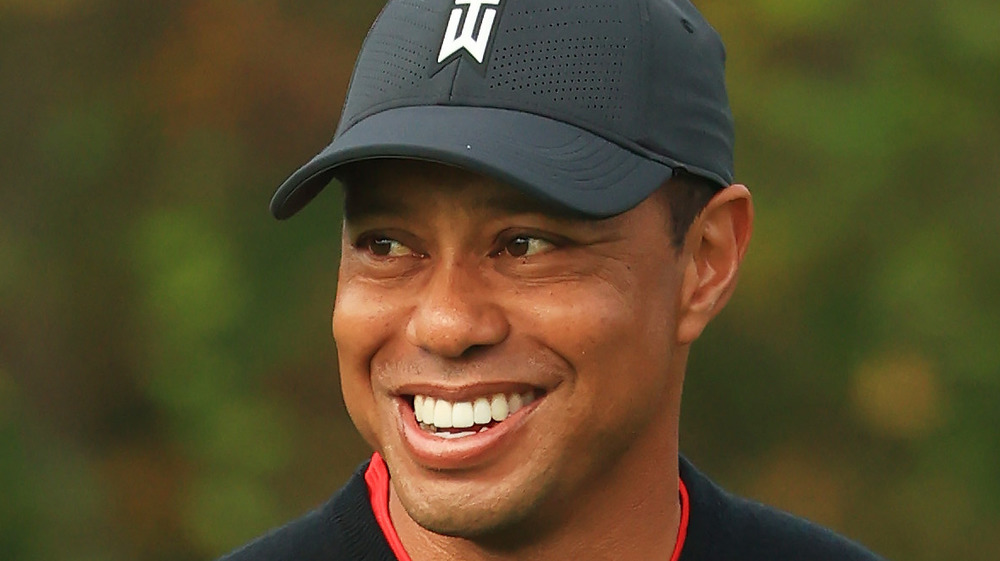 Tiger Woods, smiling, wearing cap, golfing 