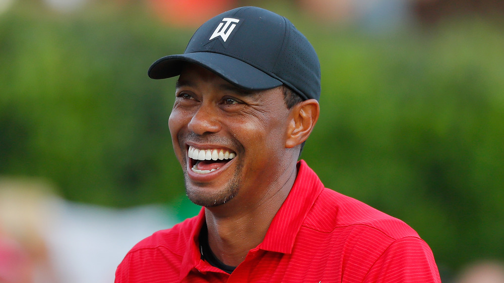 Tiger Woods in baseball cap smiling 