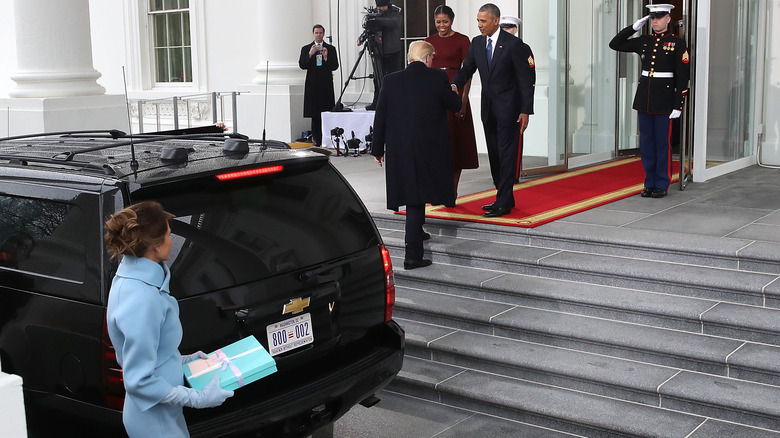 Melania Trump exiting a black car and looking at Donald Trump as he greets the Obamas on inauguration day in 2017.
