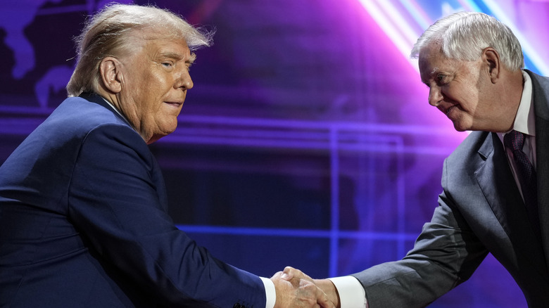 Republican presidential candidate former U.S. President Donald Trump shaking hands with Sen. Lindsey Graham (R-SC) as he arrives onstage to speak at the Faith and Freedom Road to Majority conference at the Washington Hilton