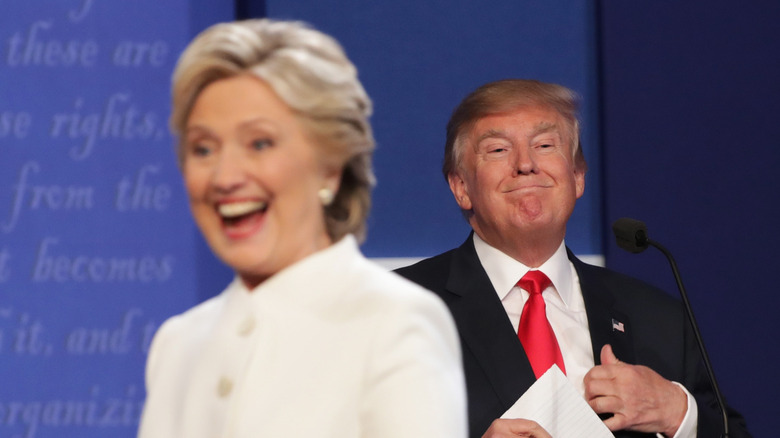 Hillary Clinton laughs with Donald Trump in the background after a 2016 debate.