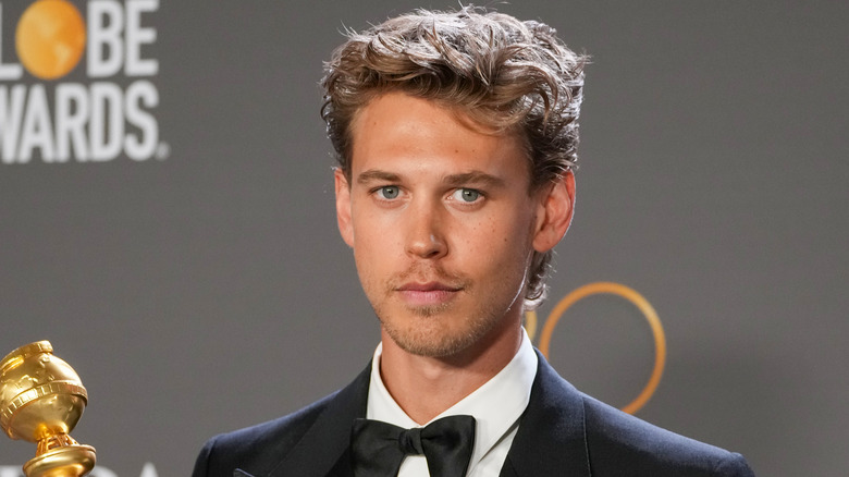 Austin Butler holding Golden Globe