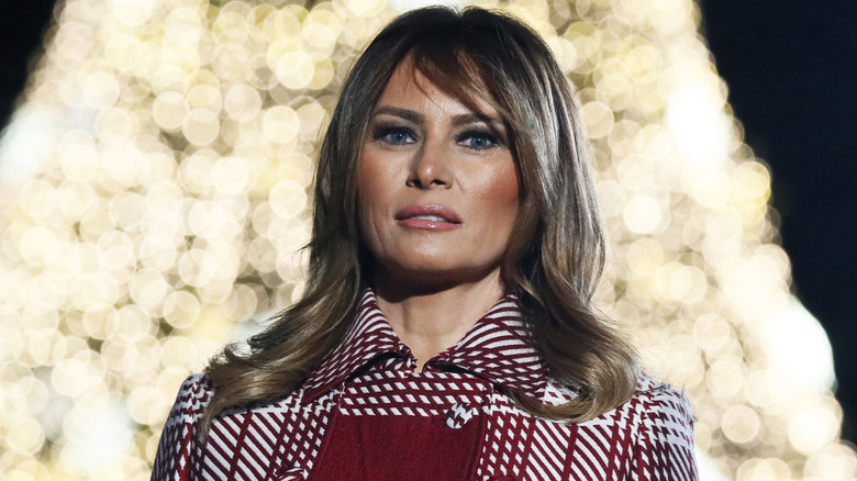 Melania Trump in front of bright white Christmas tree