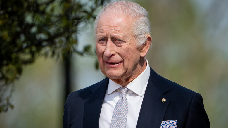 King Charles waving and smiling.