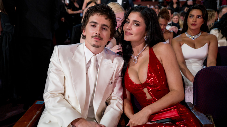 Timothee Chalamet and Kylie Jenner seated in the audience and leaning together at the 2026 Oscars.