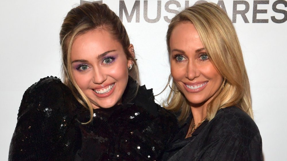 Miley Cyrus and Tish Cyrus, both wearing black and smiling