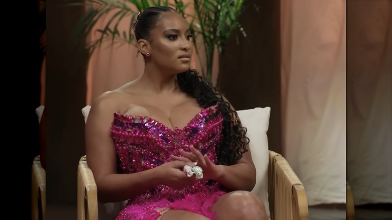 Chantelle Everette, in a hot pink outfit with a sweetheart neckline, gazes sideways.