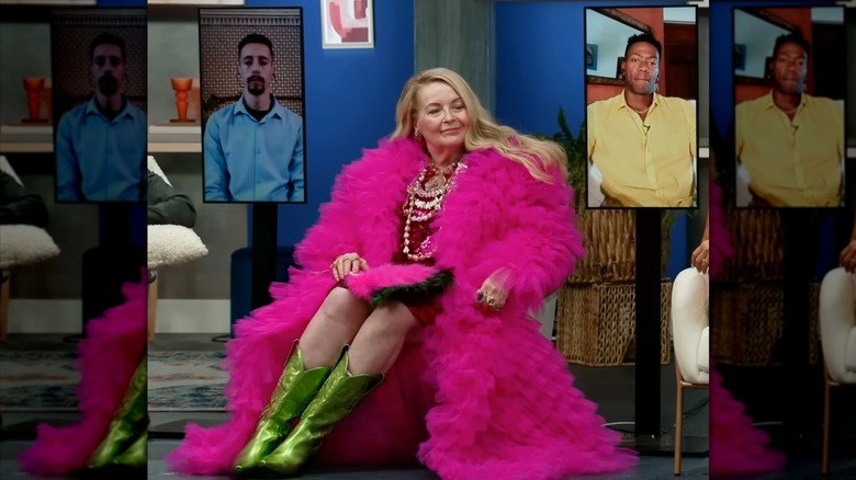 Debbie Aguero, in a vibrant pink ensemble, casts a sidelong glance.