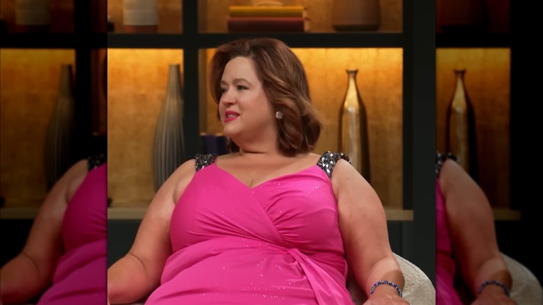 Laura Nevenner, wearing a hot pink dress, speaks while looking to the side.