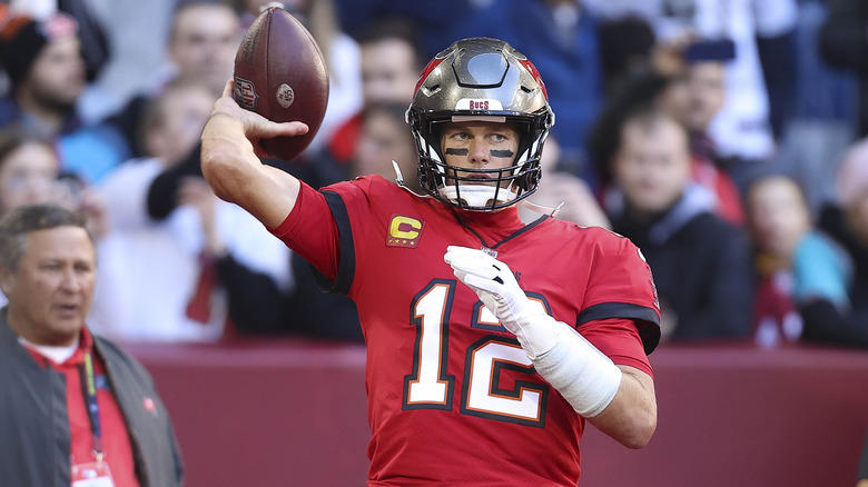 Tom Brady holds football