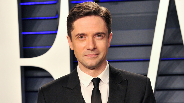 Topher Grace poses in 2019