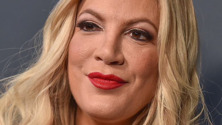 Tori Spelling poses with red lipstick