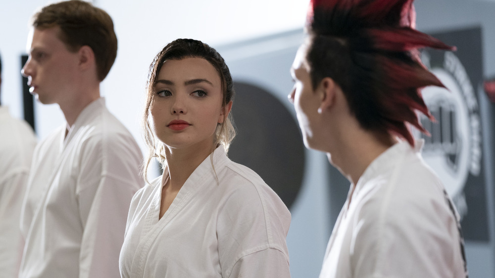 Peyton List wearing white with her hair pulled back in Cobra Kai