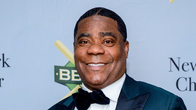 Tracy Morgan smiling while posing in a dark blue tuxedo