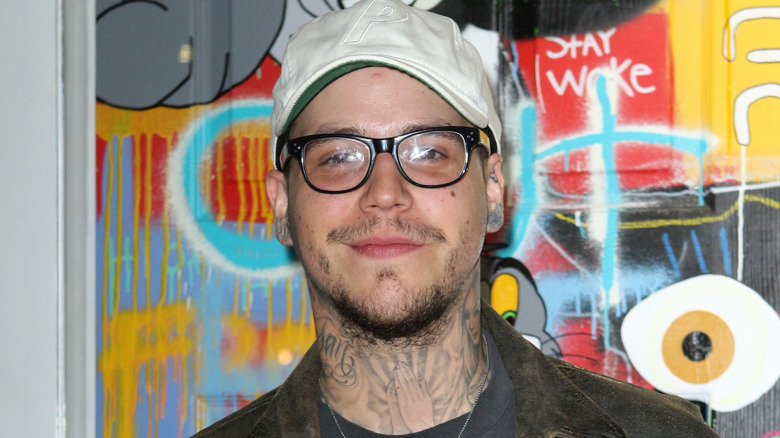 Richard Hilfiger posing in front of a graffiti wall