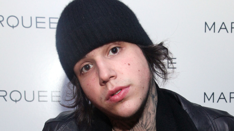 Richard Hilfiger posing for cameras on red carpet with a beanie