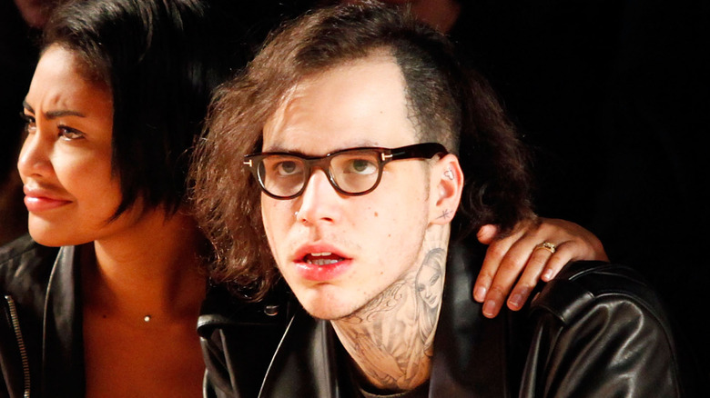 Richard Hilfiger attending a fashion show wearing glasses