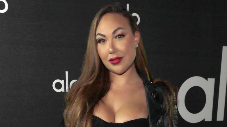 Celia Kay on red carpet wearing black dress and leather jacket