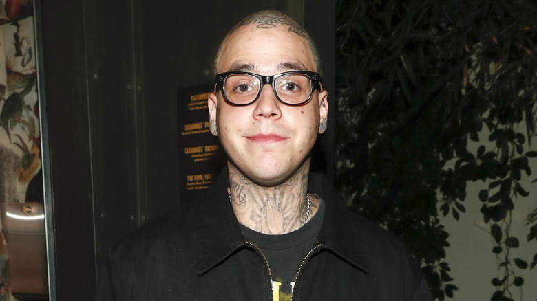 Richard Hilfiger posing for cameras wearing glasses and sporting a shaved head