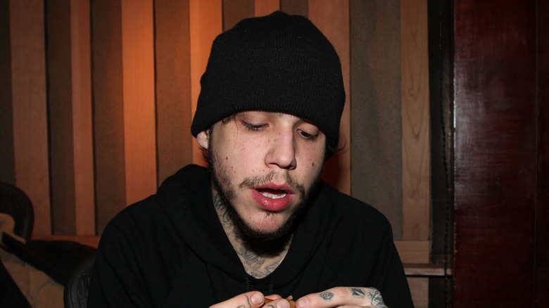 Richard Hilfiger posing for cameras looking scruffy in a beanie