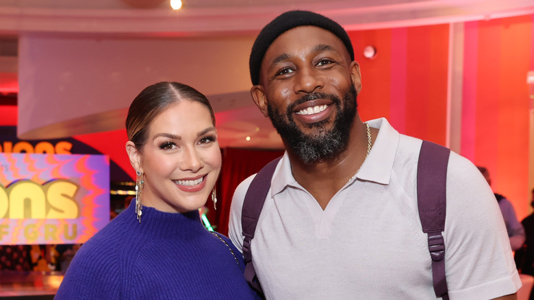 Allison Holker wearing a blue knit turtleneck dress and Stephen "tWitch" Boss wearing an off-white collared shirt and black beanie