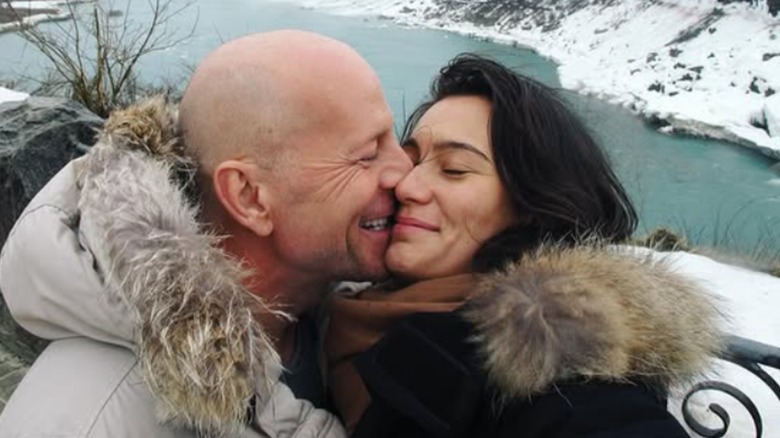 Bruce Willis and Emma Heming Willis kissing in the snow.