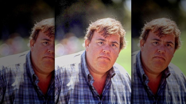 John Candy looks on with a serious expression