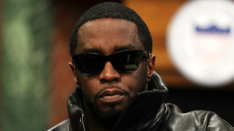 Diddy wearing a leather jacket and sunglasses